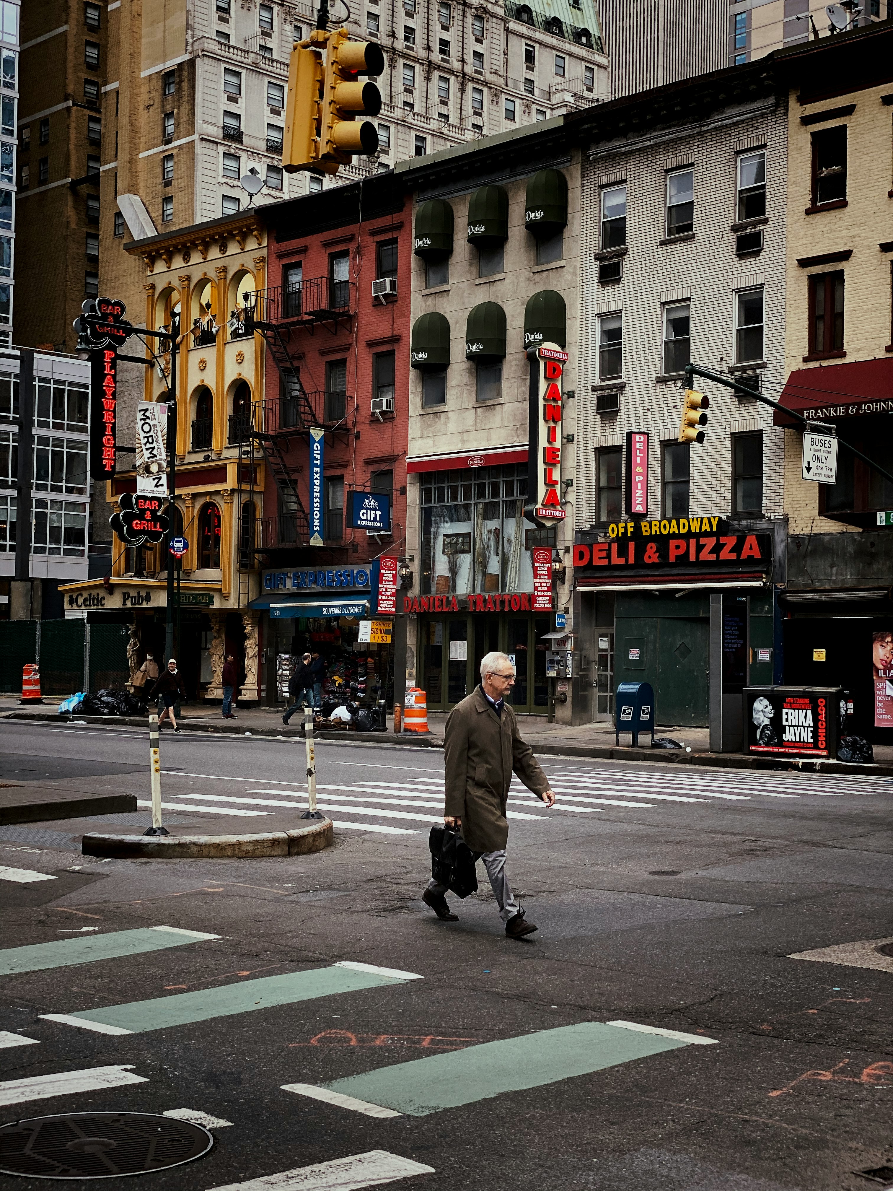 man in gray coat walking on pedestrian lane during daytime